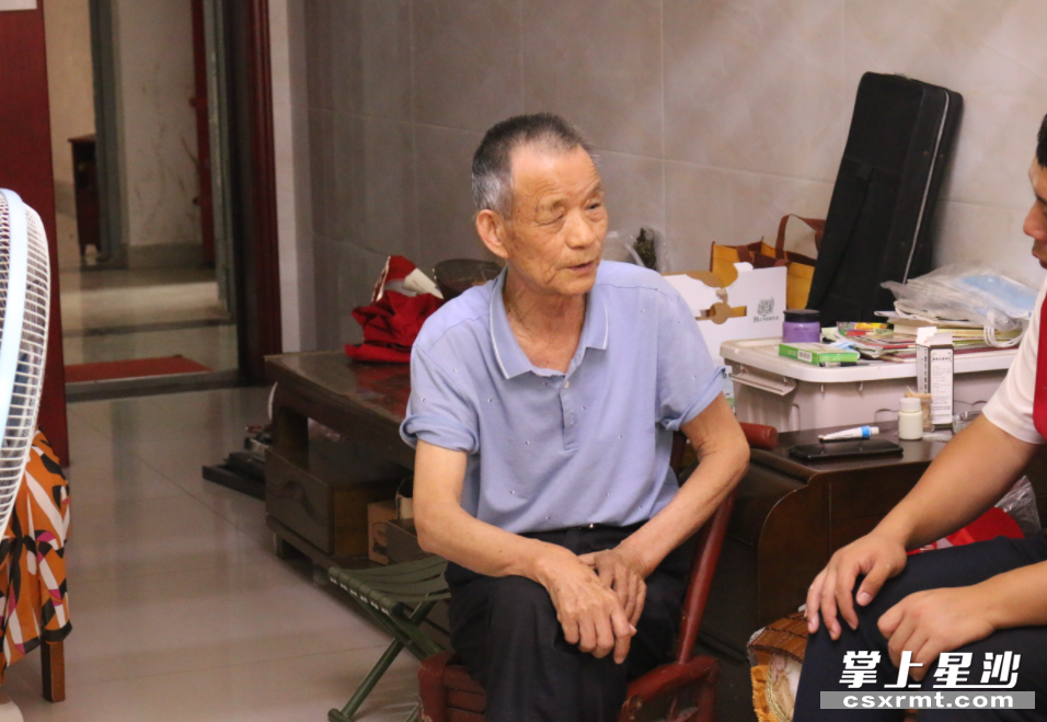 王明亮正在为社区党员志愿者讲述多年前三合村的故事.赵佳慧 摄