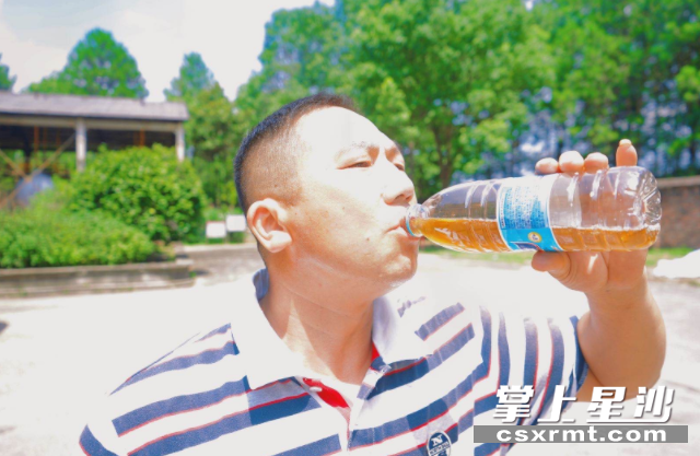 户达燃气驾驶员收车后喝凉茶解暑。