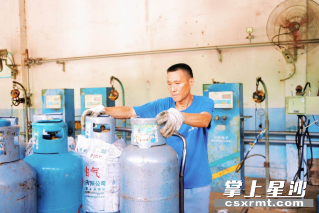 周师傅搬运空燃气罐。