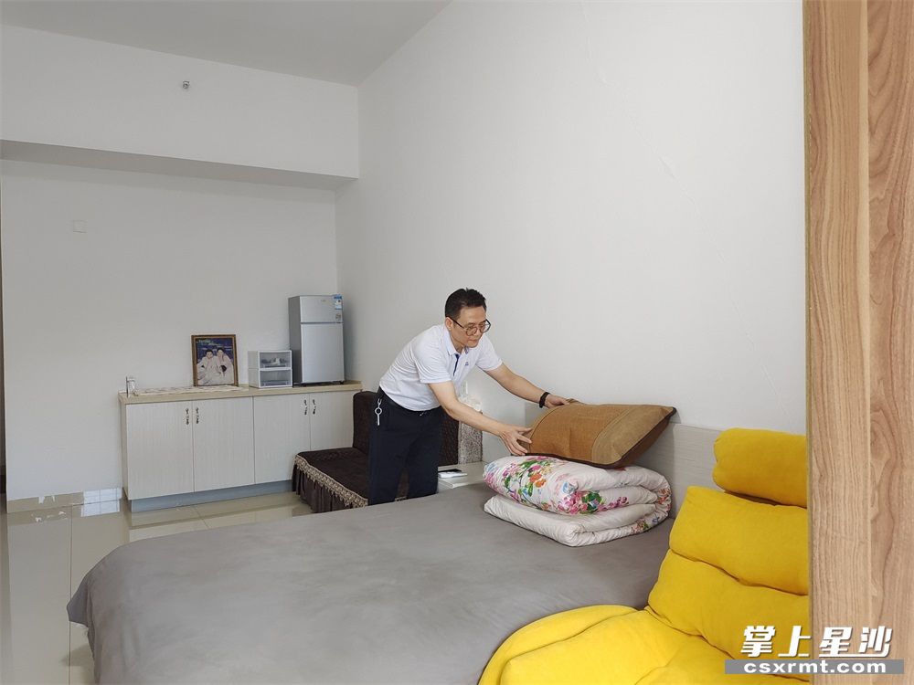 图为王拥军正在认真整理自己的床铺。 图为王拥军正在认真整理自己的床铺。