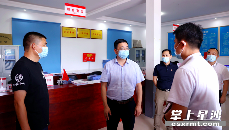 图为黄波(中)在黄兴镇打卦岭村委会督查疫情防控情况. 盛磊 摄