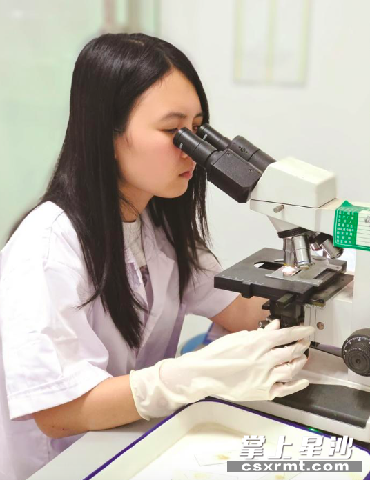 在实验室内，检测人员对相关标本进行生物相镜检。