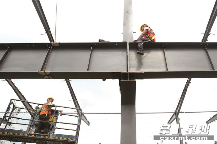 现场，建筑工人相互配合，用勤劳的双手和如雨的汗水铸造着责任担当。