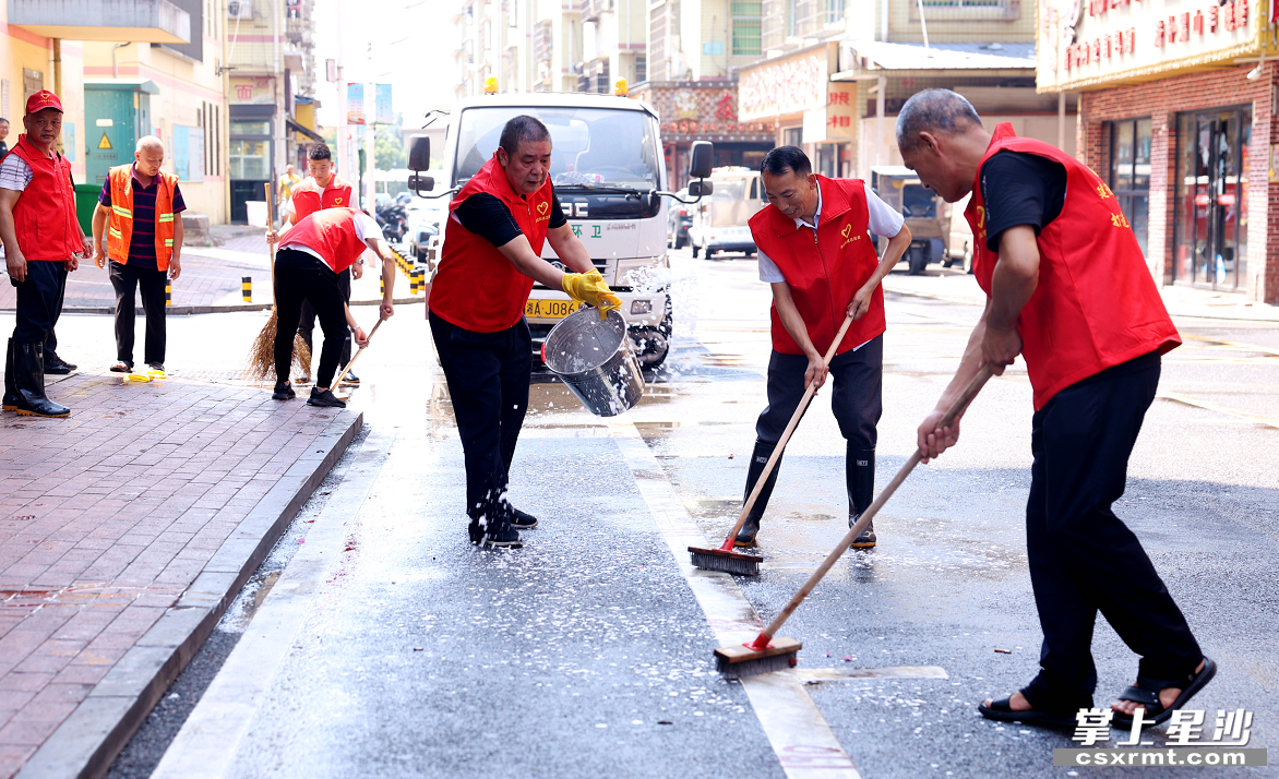 湘龙街道潇湘路社区组织志愿者清洗路面油污。 盛磊 摄