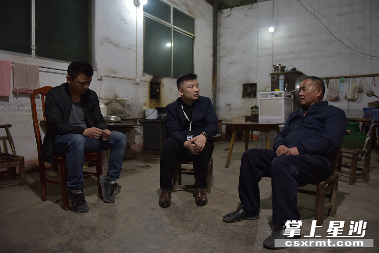 李建成（中）正在与拆迁户沟通。刘思源 摄