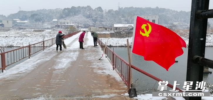 花果村第一党小组党员在枫林桥上铲雪。