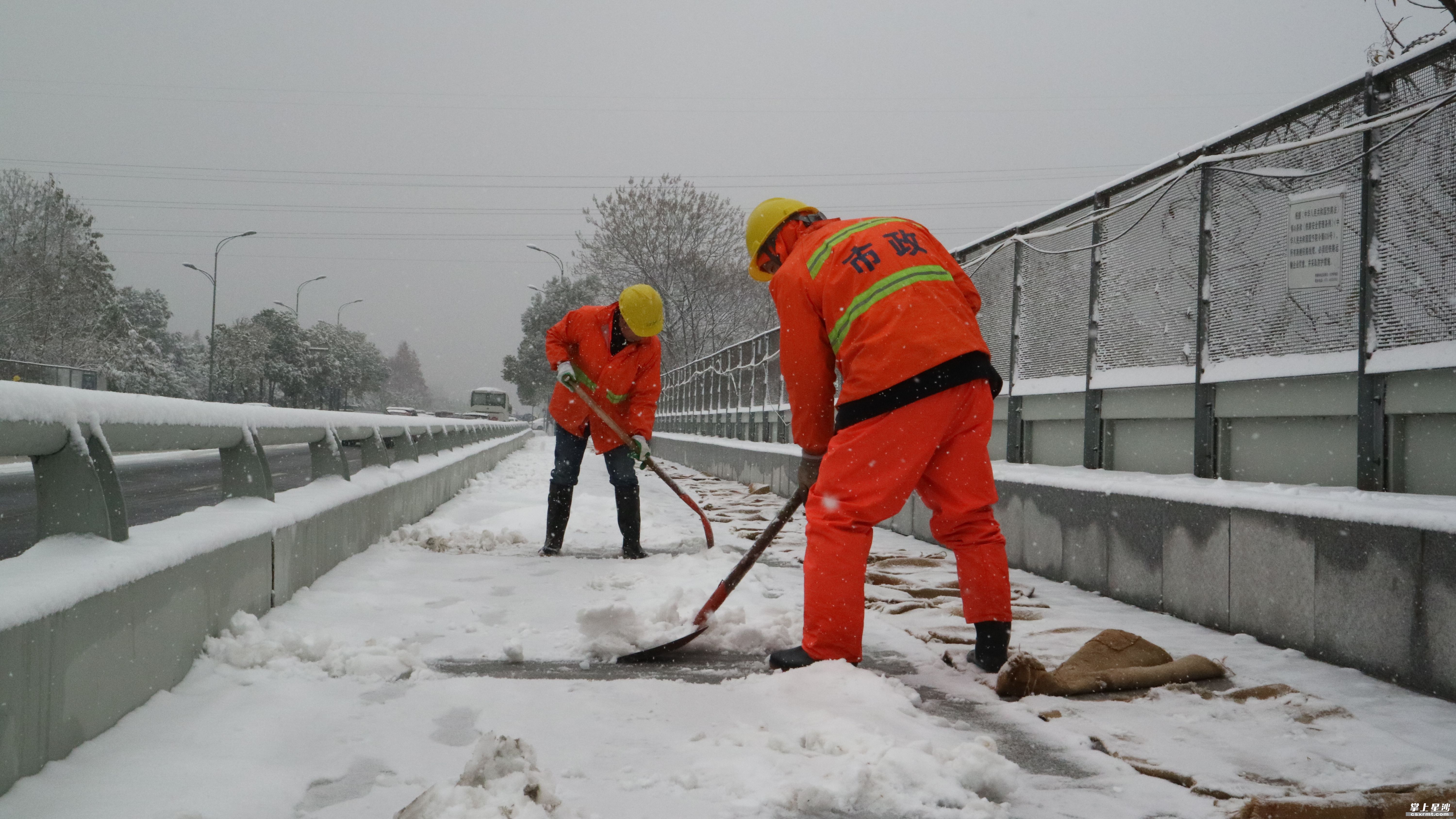 市政工人对桥面铺设麻袋,人工除雪. 罗展 摄