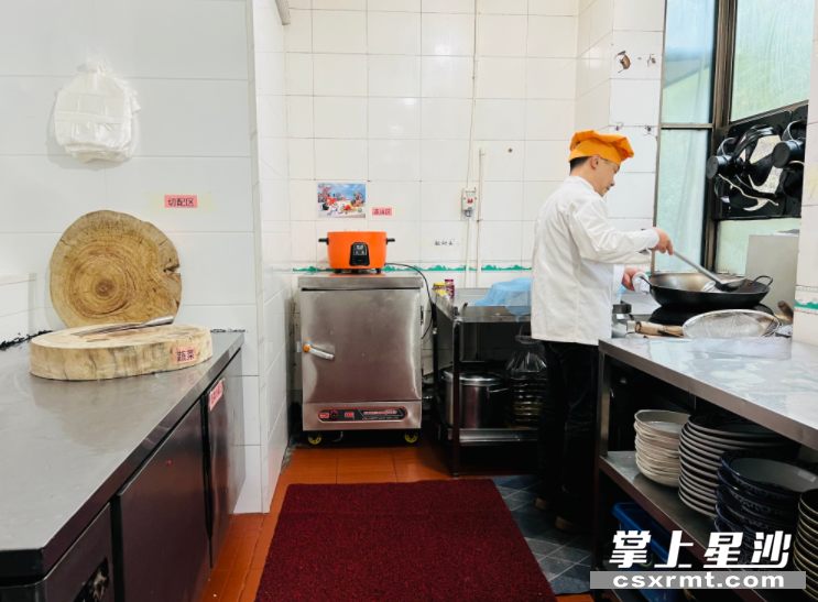 喻升华在明亮干净的后厨忙活，收拾整理厨灶和工作台。均为林正茂 摄