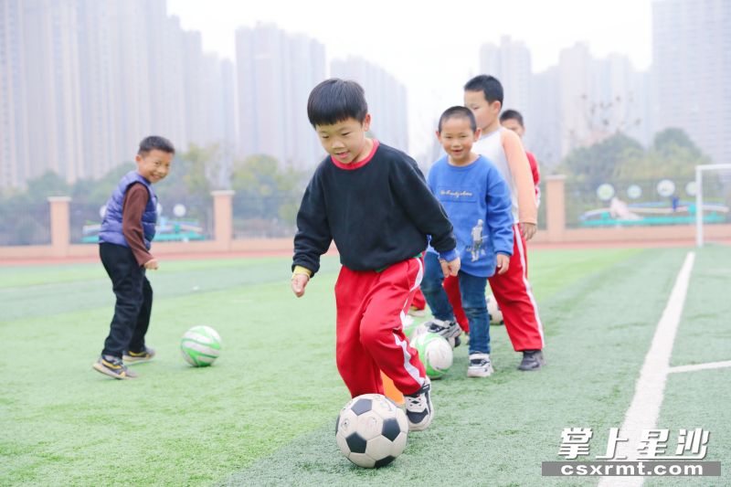 在松雅湖二小校园足球场，孩子们开心地踢足球。李杰 摄