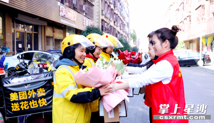 图为星沙街道妇联的志愿者向美团外卖女骑手送上节日鲜花和祝福。 盛磊 摄