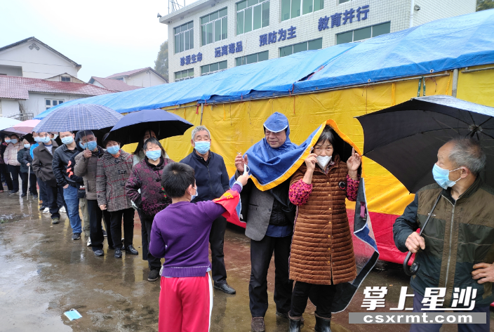 杨子飞扬为排队群众发放口罩、维持排队秩序。供图 杨子飞扬为排队群众发放口罩、维持排队秩序。供图