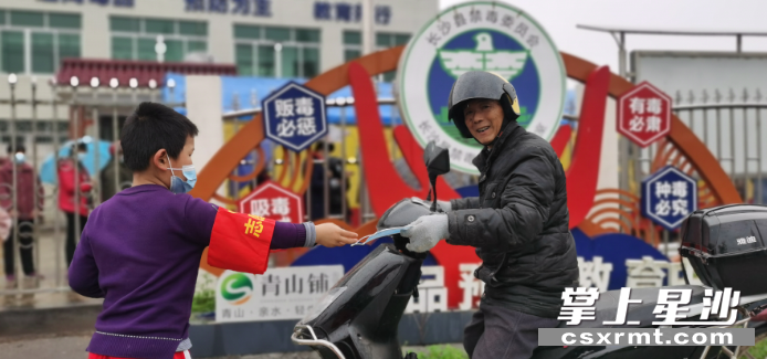 杨子飞扬为前来采样村民发放口罩。 易旭 摄 杨子飞扬为前来采样村民发放口罩。 易旭 摄