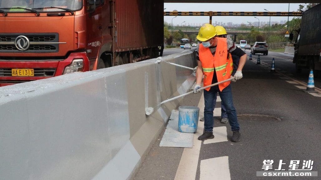 市政工人对星沙联络线沿线中央隔离墩、道路波形护栏、防护栏、外立面等防护设施进行刷漆提质。