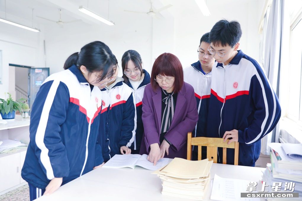 长沙县一中学生英语教师李众来课后辅导学生作业。