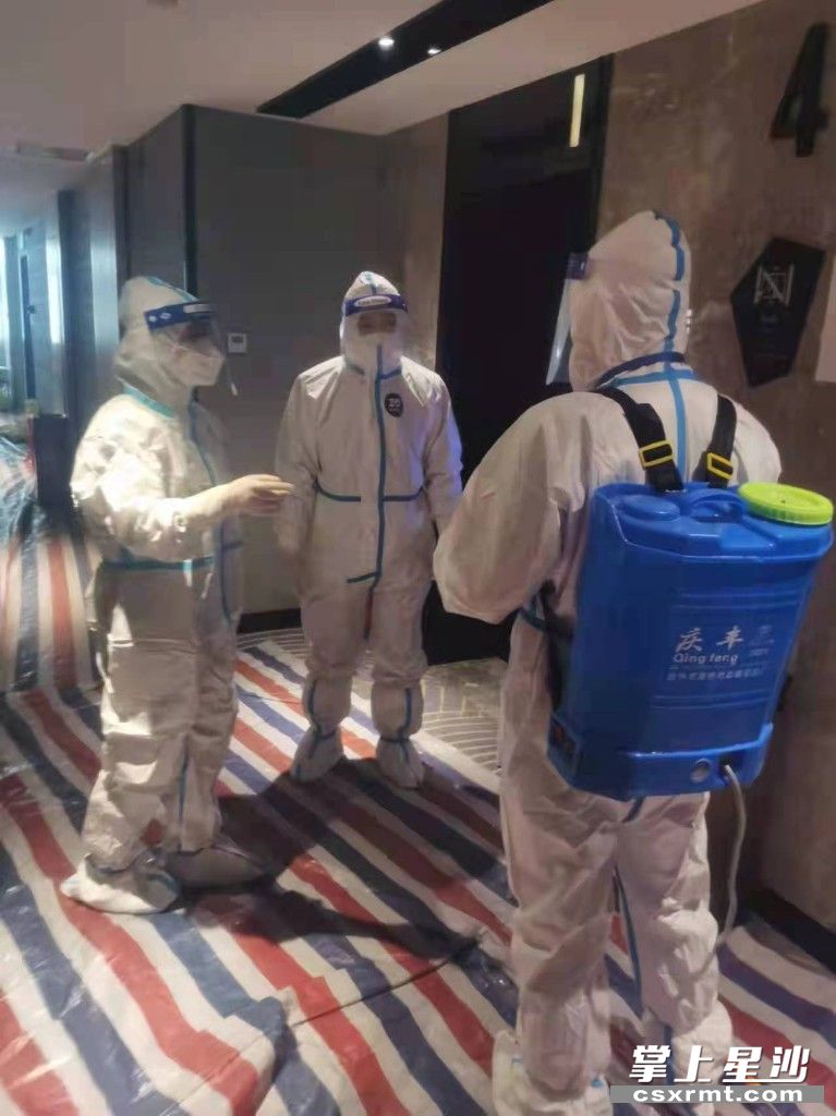 在某隔离酒店污染区，龙双（左一）详细指导消毒工作人员如何做好消毒液配比、消毒区域划分、消毒频次、个人防护等。供图