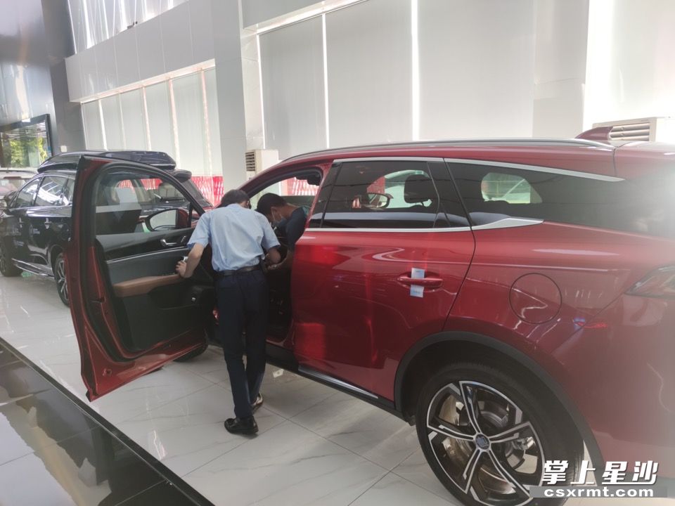 比亚迪王朝长沙金旋风4s店，销售人员正在给客户介绍新车。李丹 摄