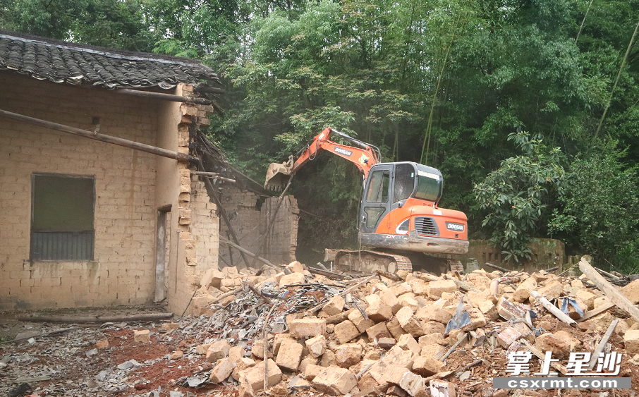 在车马村三字墙组，一台挖机振臂一挥，将一栋土砖房推倒。