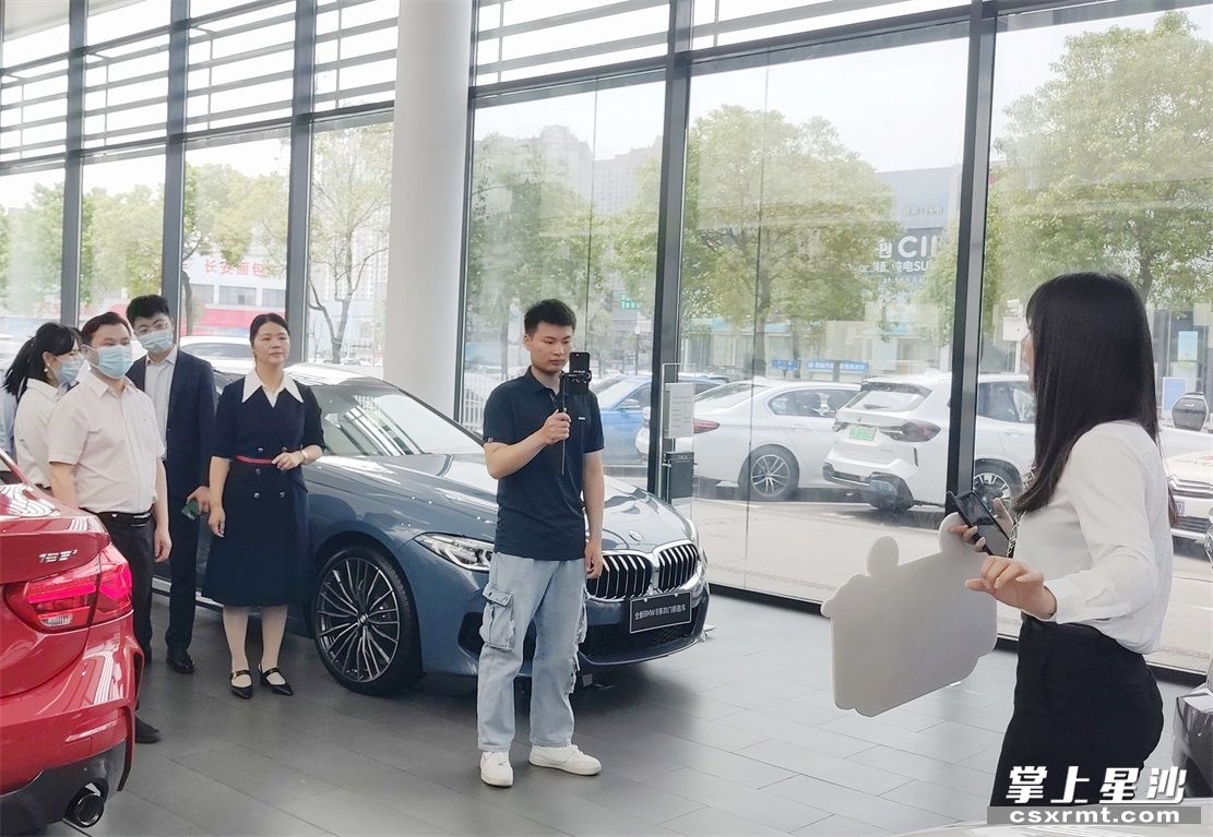 在长沙宝诚汽车销售服务有限公司，直播销售员正在热情洋溢地介绍宝马优惠活动。