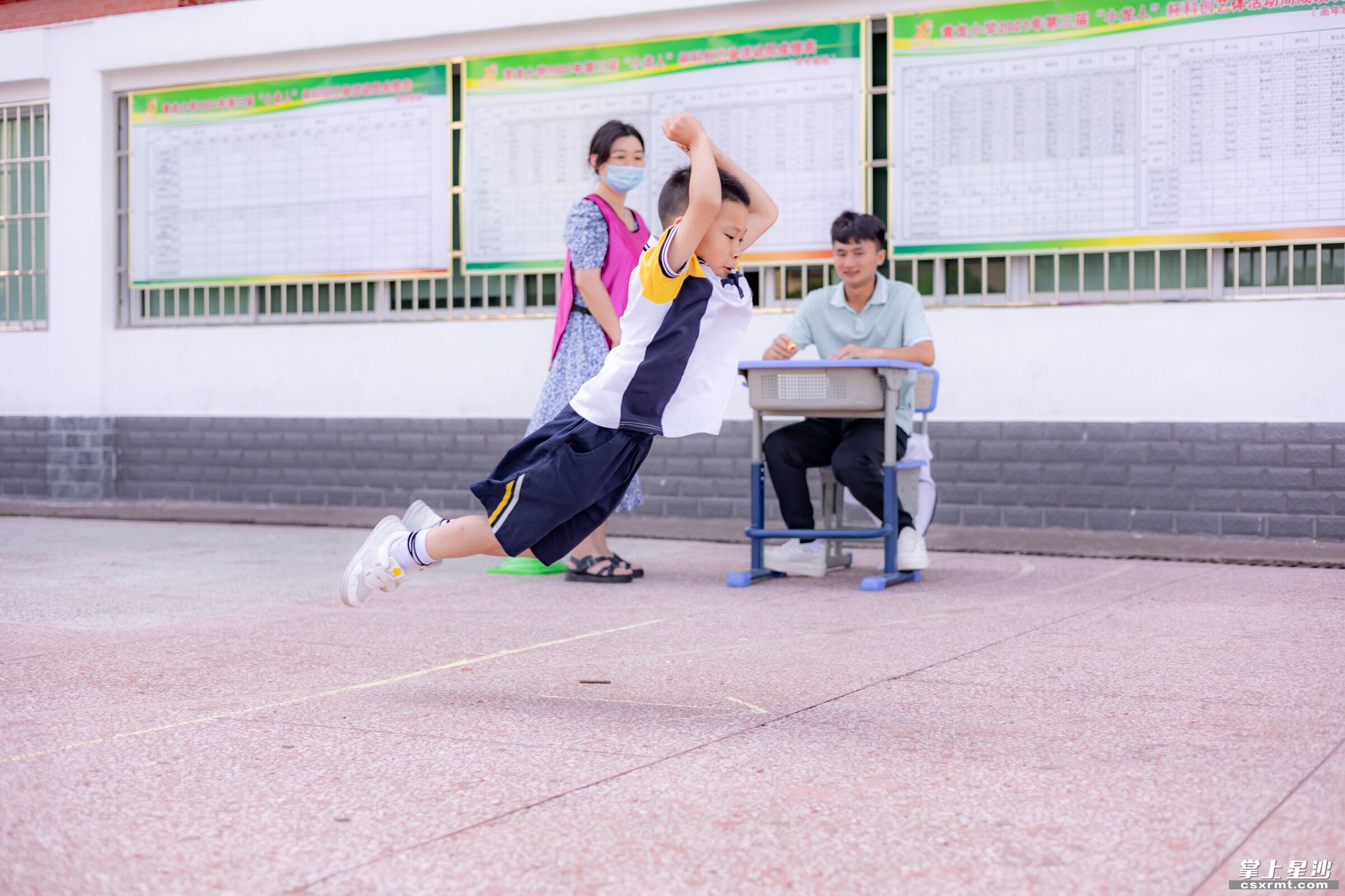 学生体育项目游考中飞跃一跳。