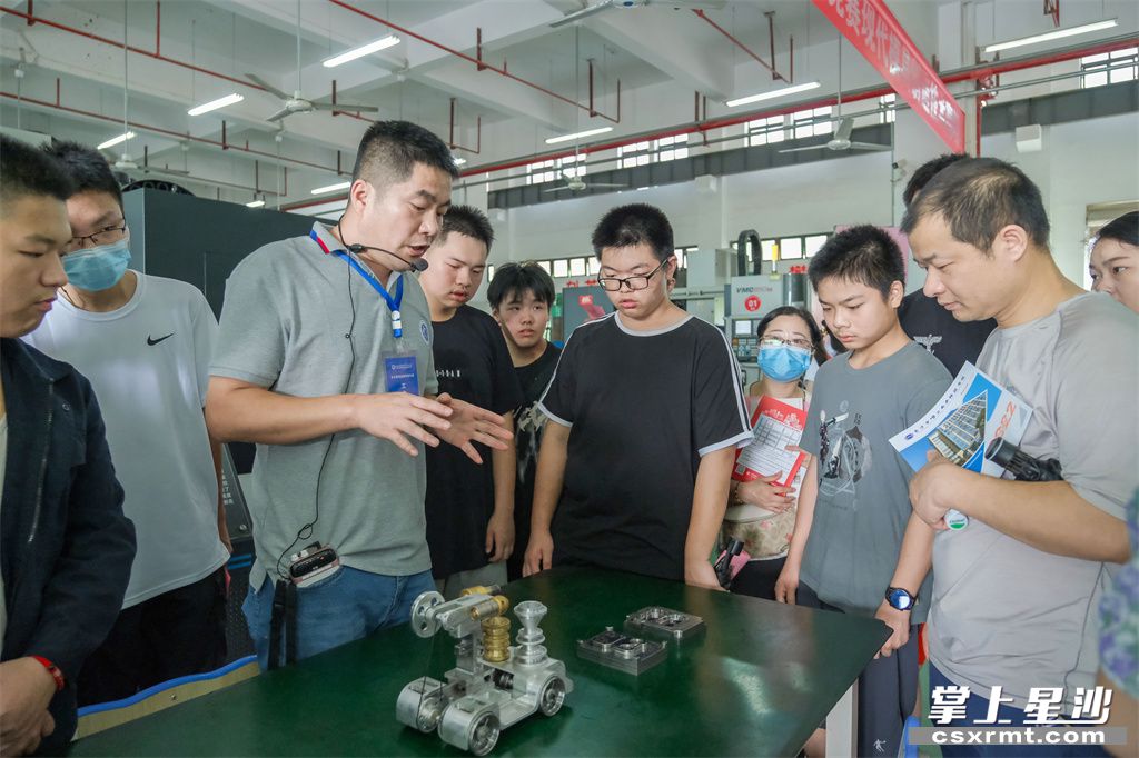 全国技术能手赵兵为家长和学生介绍机械制造专业。
