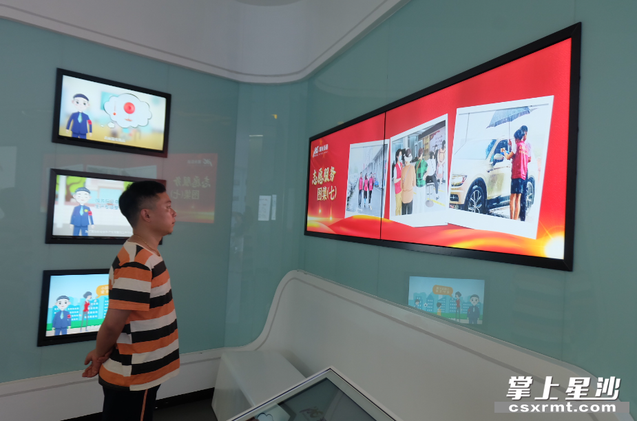居民在展厅观看志愿者风采。 居民在展厅观看志愿者风采。