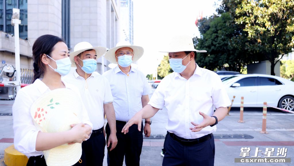 图为付旭明（右一）督查汽车站及医院周边背街小巷停车秩序整治工作。