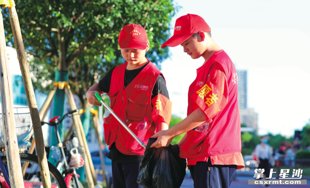 在长沙县的社区小巷、交通路口、景区景点等地，身穿红马甲的志愿者已成为这座城市一道道靓丽的风景线。 李杰 摄