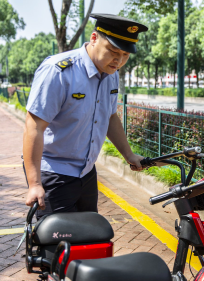 在共享单车停放点，执法队员正将单车“入位”，让文明“归位”。县行政执法局供图