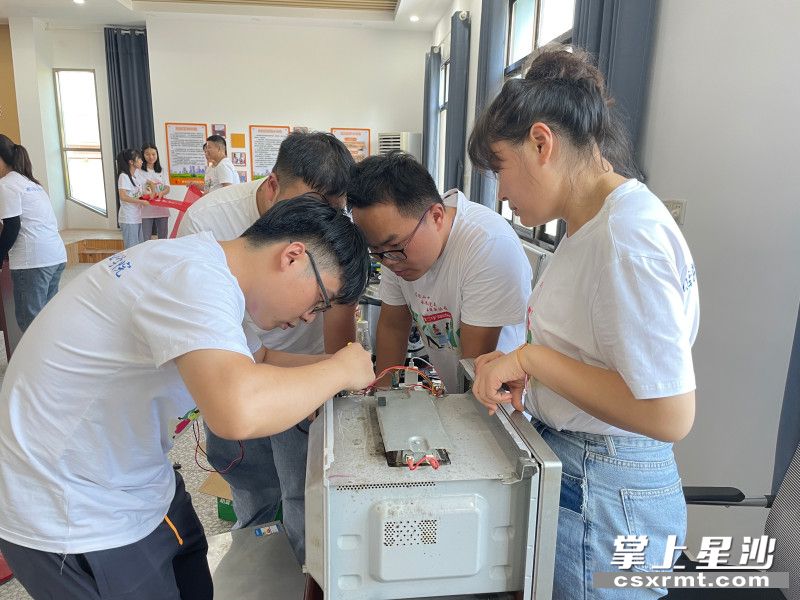 图为志愿者为居民义务维修电器。供图