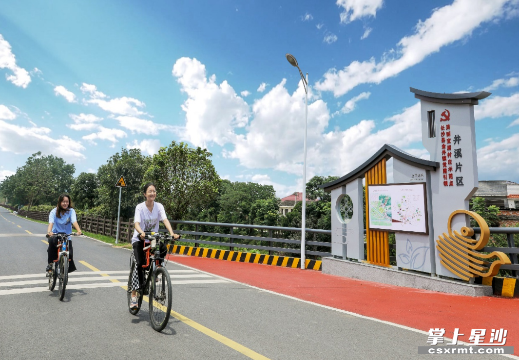 金井镇井溪片区美丽宜居村庄示范点建好后，游客们骑行游玩。 供图