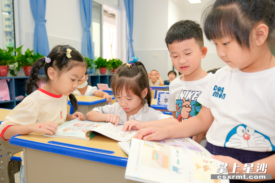 湘龙二小开学第一天，学生们开心翻阅新书。章帝 摄