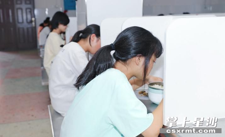 图为食堂餐桌均用隔板隔开，并且隔板上都贴有学生的名字。李杰 摄