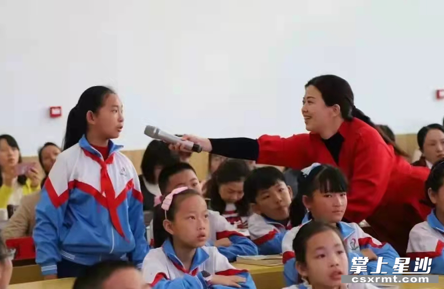 图为罗晓(右一)课堂与学生互动。黄龙小学 供图