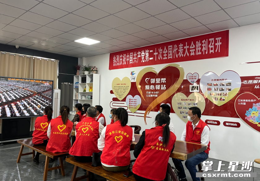 江背镇新时代文明实践所的志愿者等在收听收看党的二十大开幕会。