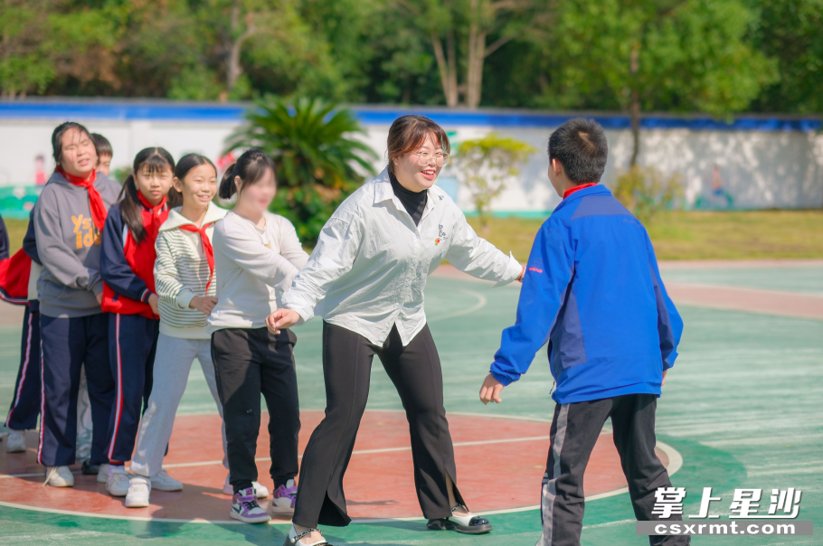 毛塘小学心理健康老师尹优带着“慢天使”在校园玩游戏。