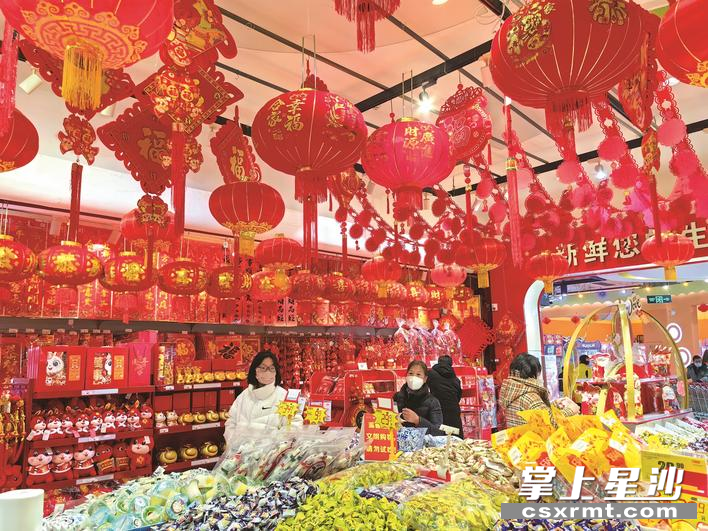 超市内，新年气氛浓厚，市民正在选购心仪的商品。李丹 摄