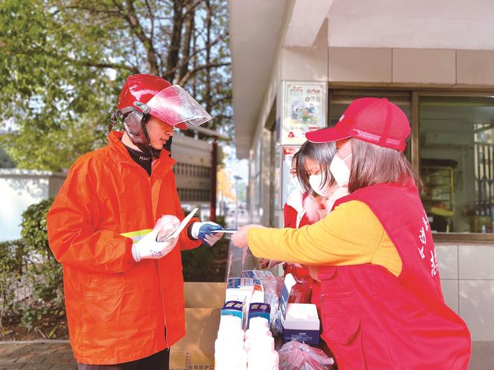 在星沙街道棠坡路，长沙县交通运输局“星锋”党员志愿者们为市民送上防疫药品。梁焕鑫 摄