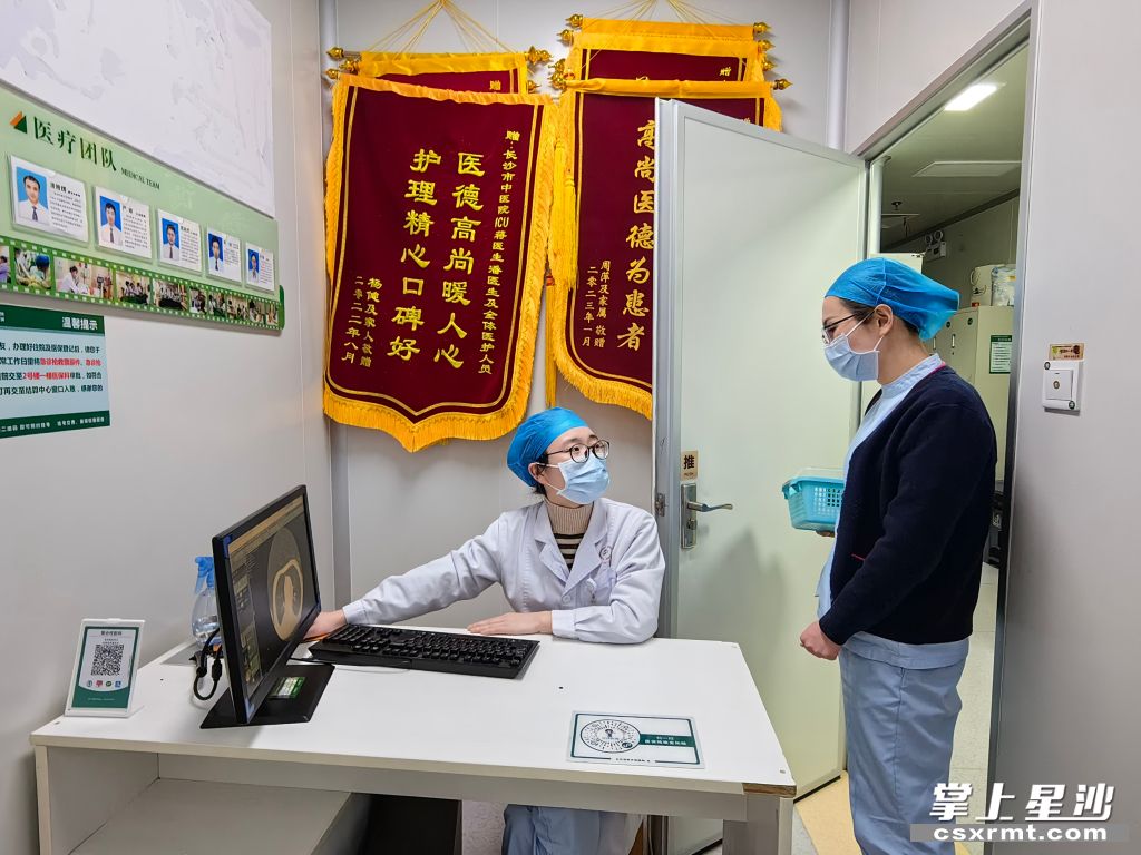 图为肖璟在跟护士沟通患者情况。