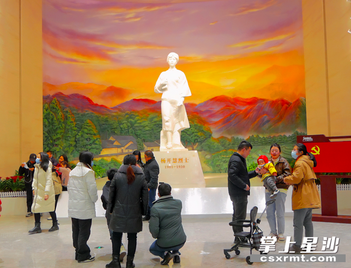 图为游客争相在杨开慧烈士生雕像前拍照留念。