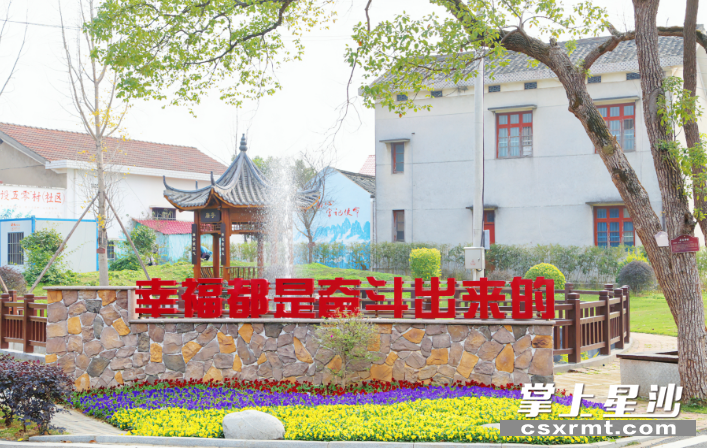 位于沿江山村湖园风光带入口处的幸福标语。