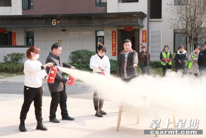 图为安全专家指导使用灭火器。长龙街道供图