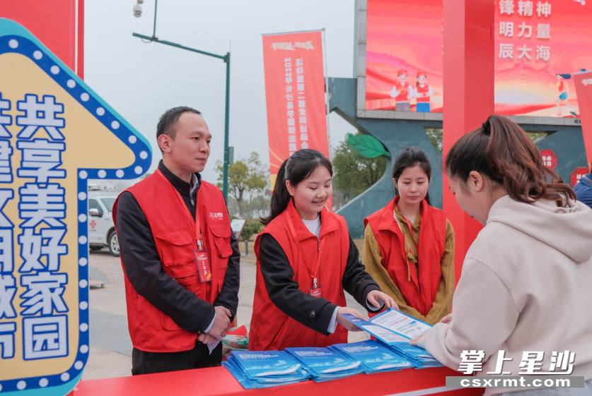 活动现场设置的政策集市区，志愿者在给市民发放宣传资料。章帝 摄