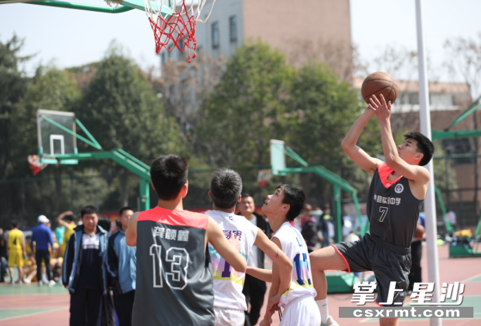 高中男子篮球赛现场，运动员起身一跃，投篮动作潇洒飘逸。