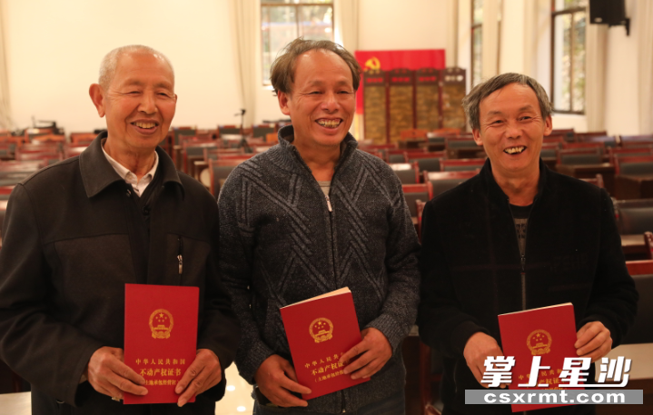 路口镇花桥湾村首批拿到不动产权证书的三位村民非常高兴。刘果林 摄