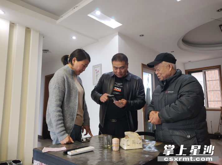 李存（中）和妻子在帮助张汉嗲嗲转存资料。