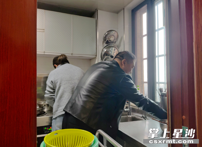 李存和妻子在一起做饭。