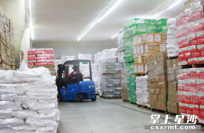 在新建的20000吨级冷库内，叉车正摆放各类冻品货物。