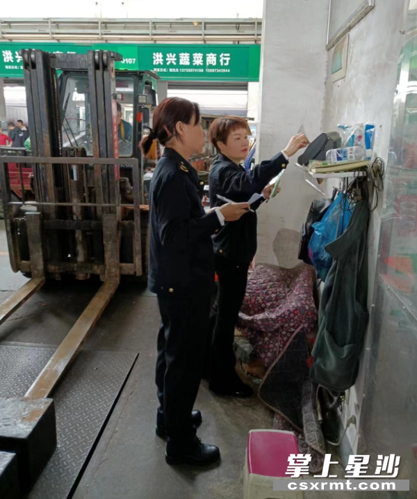 长沙县市监局计量科工作人员在市场进行监管工作。