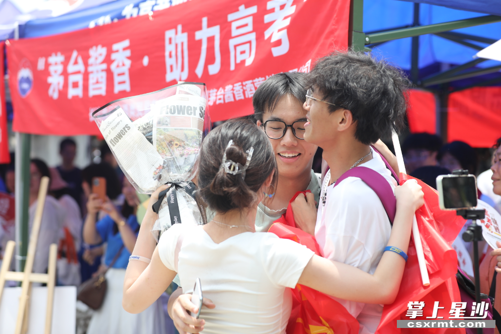 在长沙县特立中学考点，考生彭望诚（中）冲出考点，和朋友深情相拥。均为 李杰 摄