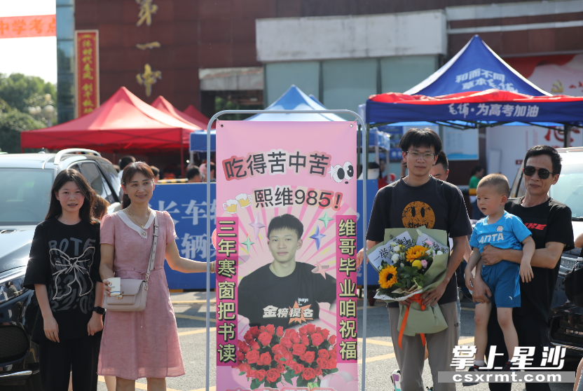 考生柳熙维一家人在长沙县一中考点附近合影留念。